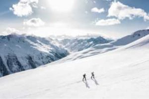 Two people cross-country skiing in the mountains