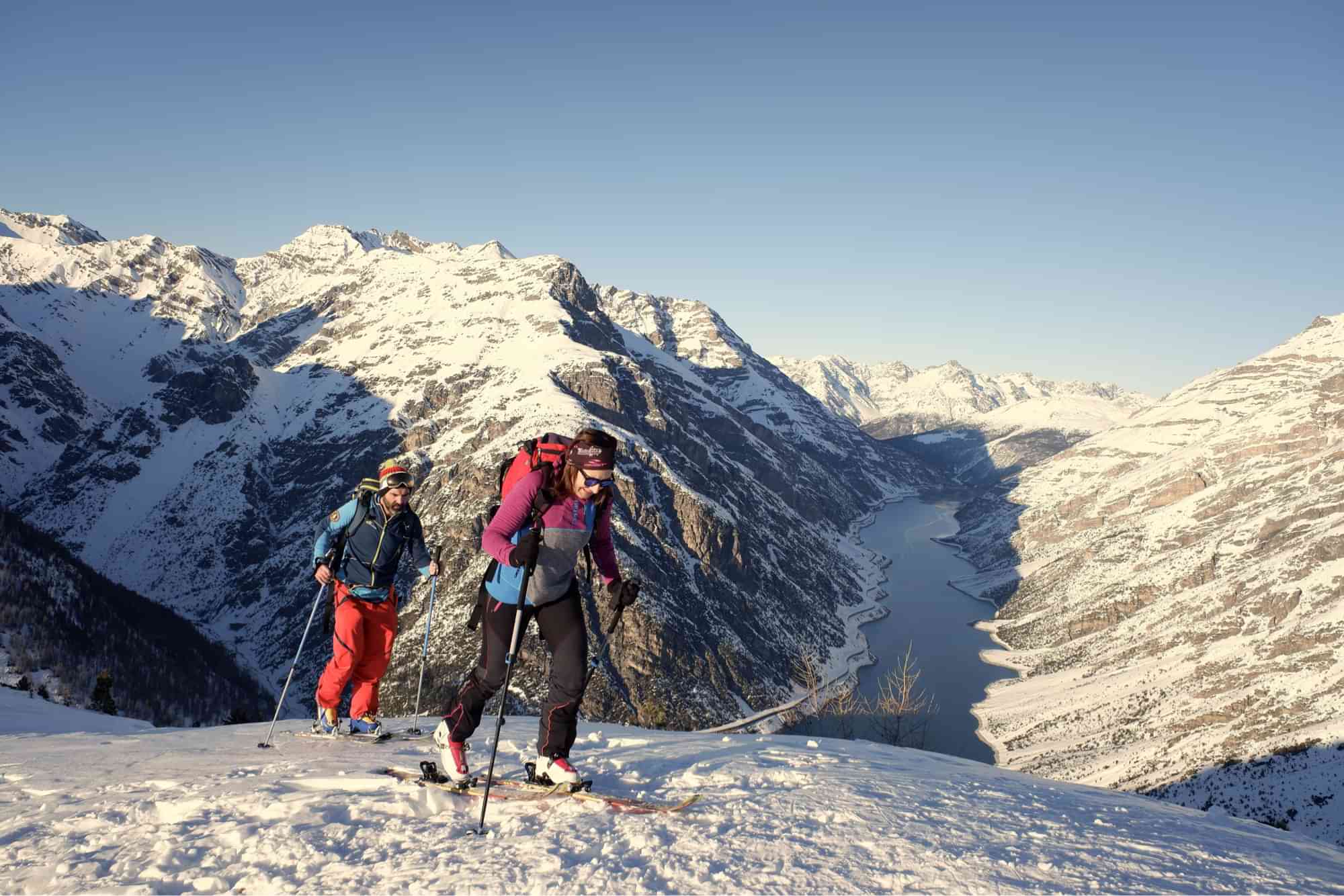 Woman and man during skimo competition to mountain summit